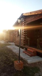 a log cabin with a light pole in front of it at Cabañas La Comarca in Concepción del Uruguay