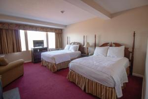ein Hotelzimmer mit 2 Betten und einem Sofa in der Unterkunft The Lucerne Inn in Dedham