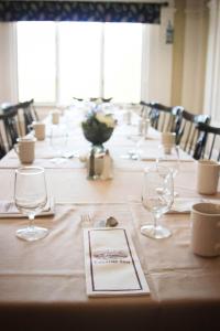 a long table with wine glasses and a menu on it at The Lucerne Inn in Dedham