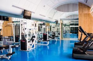 een fitnessruimte met blauwe vloeren en loopbanden bij Hotel Mirage in Querétaro