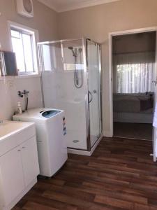 a white bathroom with a shower and a sink at Villa Asolana in Myrtleford