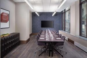 uma sala de conferências com uma mesa longa e uma televisão de ecrã plano em Hyatt Centric Faneuil Hall Boston em Boston
