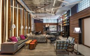 a living room with a couch and chairs and a table at Hyatt Herald Square New York in New York