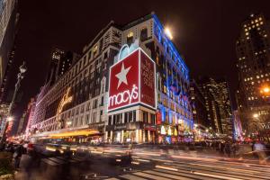 a busy city street at night with a macys building at Hyatt Herald Square New York in New York