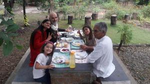 un grupo de personas sentadas alrededor de una mesa de picnic en Tranquilandia, en Varagampadi