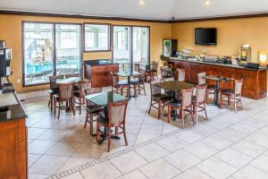 a restaurant with tables and chairs and a bar at Quality Inn & Suites in Seville