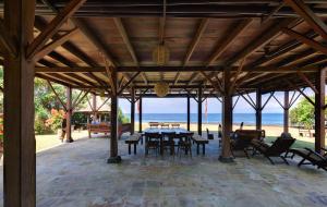 a pavilion with tables and chairs and the beach at Jasri Bay Hideaway in Jasri