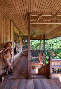 a wooden porch of a house with a statue of a woman at Jasri Bay Hideaway in Jasri