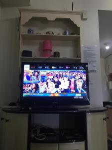 a flat screen tv sitting on top of a table at TAGAYTAY WIND CONDO, 4pax,3BEDS,FF,AC WIFI in Tagaytay