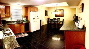 a kitchen with a white refrigerator and a black tile floor at The Haven at Charity House in Waldorf