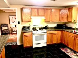 a kitchen with wooden cabinets and a white stove top oven at The Haven at Charity House in Waldorf +31 photos