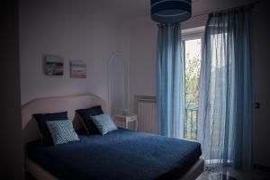 Un dormitorio con una cama azul y una ventana en La Gemma di Ravello en Ravello