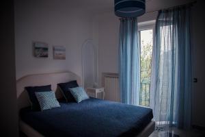 a bedroom with a blue bed and a window at La Gemma di Ravello in Ravello