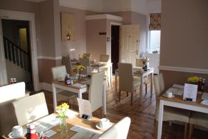 a restaurant with tables and chairs in a room at The Kenbury B&B in Shanklin