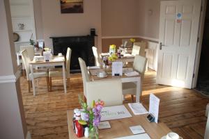 a living room with tables and chairs with flowers on them at The Kenbury B&B in Shanklin +29 photos