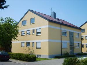 a large yellow building with a red roof at BodenSEE Apartment Langenargen Möwenweg in Langenargen