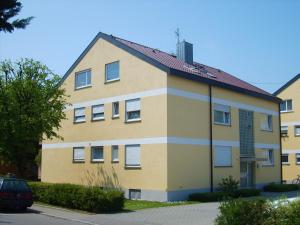ein großes gelbes Gebäude mit rotem Dach in der Unterkunft BodenSEE Apartment Langenargen Möwenweg in Langenargen