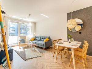 - un salon avec un canapé bleu et une table dans l'établissement Apartament SURF SurfingBird Kołobrzeg, à Kołobrzeg