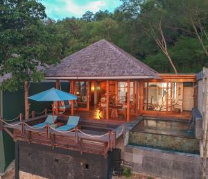 a house with a wooden deck with a swimming pool at Bayview Gardens Hotel in Labuan Bajo