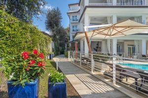 una casa con piscina, sombrilla y flores en Hotel Central Park, en Marina di Pietrasanta