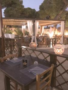einen Holztisch mit Stühlen und Lampen auf einer Terrasse in der Unterkunft Affittacamere la Medusa in Porto Pino