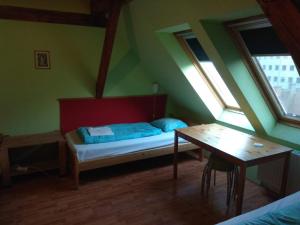 a room with a bed and a table and windows at 7x24 Central Hostel in Budapest