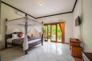 a bedroom with a bed with a canopy at Pondok Wisata Sartaya 2 in Lovina