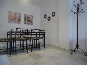 Pokój ze stołem i krzesłami oraz ścianą z zegarami w obiekcie Apartamento Oropendola 9 w mieście El Puerto de Santa María