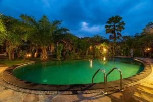 una piscina en un complejo por la noche en Pondok Wisata Sartaya 2, en Lovina