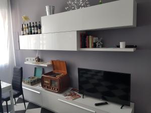 a desk with a tv and a computer on it at Appartamento Saretta in Asti