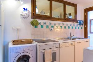 a kitchen with a washing machine and a sink at Villa Madreperla in Marciana