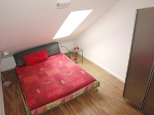 um quarto com uma cama com um cobertor vermelho em Ruhepol em Travemünde