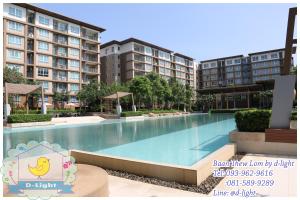 a large swimming pool in front of some apartment buildings at Baan Thew Lom by D-light in Cha Am