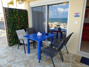 Una mesa y sillas azules en una habitación con ventana. en Rubini Homes, en Agia Marina de Nea Kydonia