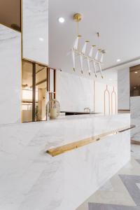 a kitchen with white marble countertops and a dining room at The 8 Hotel Udonthani in Udon Thani