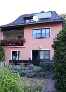 ein rosa Haus mit einer Bank davor in der Unterkunft Ferienwohnung Hoffmann in Rathmannsdorf