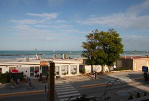 un bâtiment dans une rue avec l'océan en arrière-plan dans l'établissement Hotel Velus, à Civitanova Marche