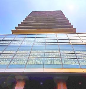 a tall building with a lot of glass windows at Swiss-Belhotel Blulane in Manila