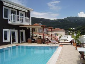 a woman sitting in a chair next to a swimming pool at Altanahouse in Parga