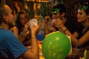 um grupo de pessoas sentadas numa mesa com um balão verde em Arcadia Hostel Medellin em Medellín