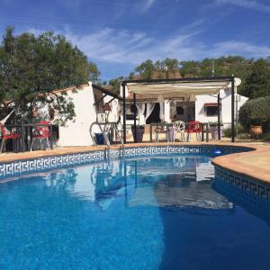 una piscina de agua azul frente a una casa en B&B Sol y Monte en Alora