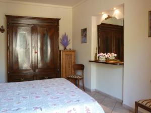 グレーヴェ・イン・キアンティにあるLa Casina Appartamento nel Cuore di Greve in Chiantiのベッドと木製のキャビネットのある寝室