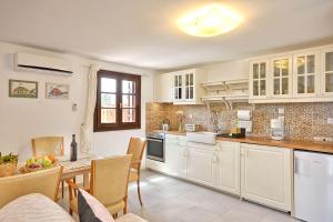 a kitchen with white cabinets and a table and chairs at CENTER Penthouse - MEDIEVAL Town 10'- BEACH 2' in Rhodes Town