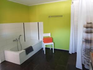 a bathroom with a bath tub and a chair at Haus Lisbeth in Malschwitz
