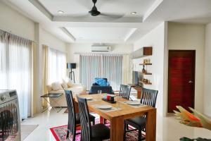 ein Esszimmer und ein Wohnzimmer mit einem Tisch und Stühlen in der Unterkunft Aonang Private Villa - Private Pool & Garden in Ao Nang Beach