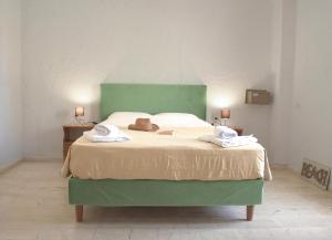 a bedroom with a green bed with a hat on it at Arhodiko Hotel in Amoudara Herakliou