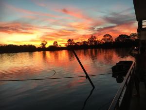 una barca su un lago con un tramonto sullo sfondo di Rivershack Pet Friendly a Renmark