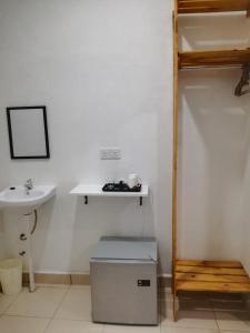 a bathroom with a sink and a toilet and a shelf at ROSA Motel in Pantai Cenang