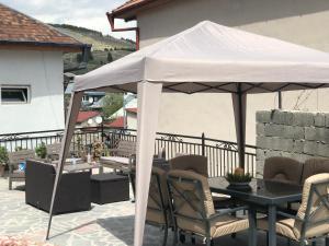 a white umbrella on a patio with a table and chairs at Hotel Terrace Rabath in Akhaltsikhe