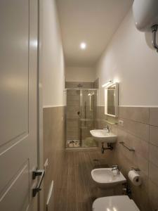 uma casa de banho com um WC, 2 lavatórios e um chuveiro em SILIA HOUSE Napoli Centro em Nápoles